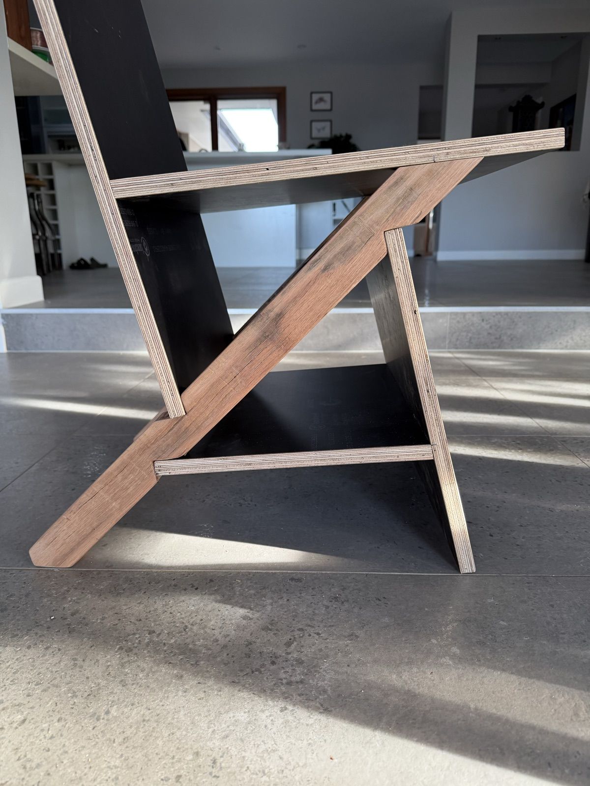 Side elevation of the K2-Keel chair, black plywood back, seat, front and tie on a hardwood keel at 45 degrees