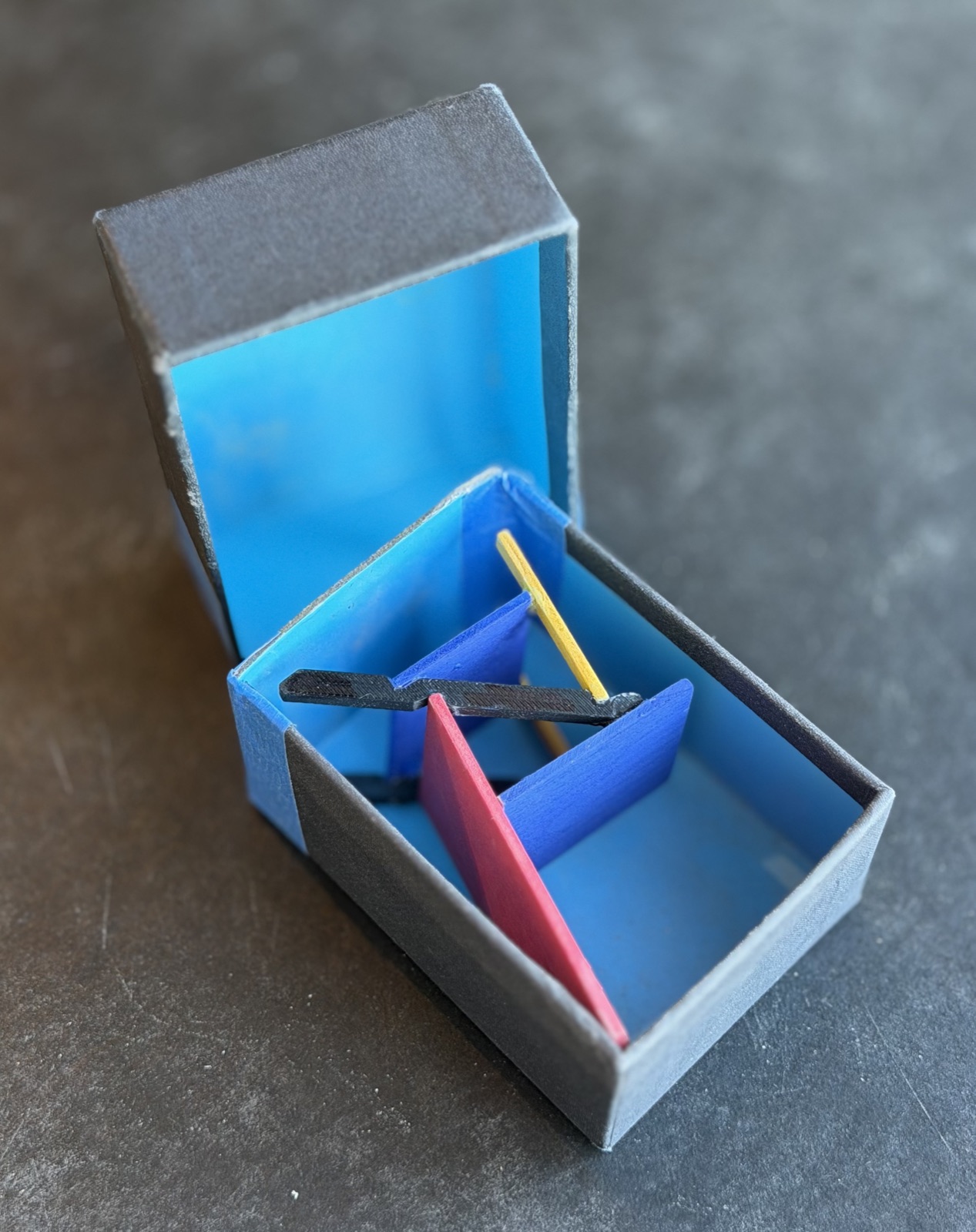 An open gray box lined in blue holding the painted chair model